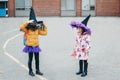 Happy Halloween. Children girls friends in costumes and face protective masks going to school. People school students celebrating