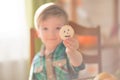 Happy Halloween concept. Cute little happy boy carving a pumpkin and decorated cookies for halloween on table indoors. Royalty Free Stock Photo