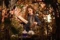 Happy Halloween Concept! Cute little witch cooking a potion in the decorated garden Royalty Free Stock Photo