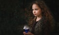 Happy Halloween Concept! Cute little witch cooking a potion in the decorated garden Royalty Free Stock Photo