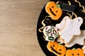 Happy halloween cookies on a black plate