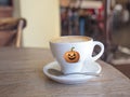A happy Halloween Cup of coffee with a pumpkin spooky face