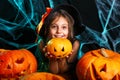 Happy halloween. Pretty little child girl in witch costume with carving pumpkin . Happy family preparing for Halloween. Royalty Free Stock Photo