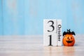 Happy Halloween day with 31 October calendar wood, jack o lantern pumpkin and bat decor with funny face on table background with