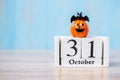 Happy Halloween day with 31 October calendar wood, jack o lantern pumpkin and bat decor with funny face on table background with Royalty Free Stock Photo