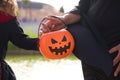 Happy halloween. Details of hands of pretty young woman and girl dressed as witches by the lake in the park and with a pumpkin to