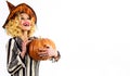 Happy Halloween. Emotional girl in witch hat with jack-o-lantern. Smiling woman with Pumpkin. Traditional food. Copy
