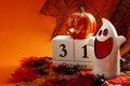 Happy Halloween and fall holiday season concept theme with ghost, jack o lantern, block calendar set to October 31, dead leafs,