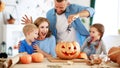 Happy Halloween! family mother father and children cut pumpkin for holiday at home