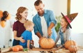 Happy Halloween! family mother father and children cut pumpkin for holiday at home