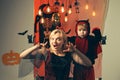 Mother wearing as witch, son wearing as devil. Boy in devil costume. Beautiful young woman with a child with pumpkins Royalty Free Stock Photo