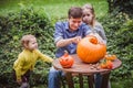 Happy halloween. Father and two daughter carving pumpkin for Halloween outside. Happy family Royalty Free Stock Photo