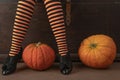 Happy halloween! Female feet in stockings with an orange pumpkin.