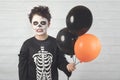 Happy Halloween. funny child in a skeleton costume with colorful balloons