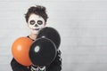 Happy Halloween. funny child in a skeleton costume with colorful balloons