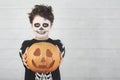 Happy Halloween.funny child in a skeleton costume with halloween pumpkin