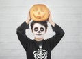 Happy Halloween.funny child in a skeleton costume with halloween pumpkin over on his head