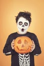 Happy Halloween.funny child in a skeleton costume with halloween pumpkin over on his head