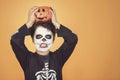 Happy Halloween.funny child in a skeleton costume with halloween pumpkin over on his head