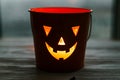 Happy Halloween. Glowing Jack-o-lantern face in dark. Spooky atmospheric jack o lantern glowing pumpkin bucket on black background Royalty Free Stock Photo