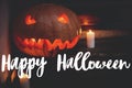 Happy Halloween greeting card. Hand written Happy Halloween text on background of spooky pumpkin Jack-o`-lantern with glowing fac Royalty Free Stock Photo