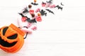 Happy Halloween. Halloween candy spilled from jack o lantern bucket with skulls, black bats, ghost, spider decorations on white Royalty Free Stock Photo