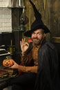 Happy Halloween. Halloween wizard smiling with pumpkin on wooden wall