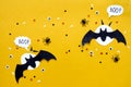 Happy halloween holiday concept. Black glitter paper bats and moon on bright yellow background with black spider, eyes Royalty Free Stock Photo