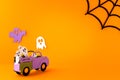 Happy halloween holiday concept. Halloween handmade paper decorations, spiders, spider web, ghosts in car on orange Royalty Free Stock Photo