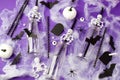 Happy Halloween holiday concept. Scary decorations, spider web, pumpkins, bats, bottles for cocktails and straws on purple Royalty Free Stock Photo