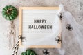 Happy halloween holiday concept. Skeletons, spider, web, pumpkin, text on board frame on concrete grey background Royalty Free Stock Photo