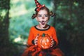 Happy Halloween! horrible creepy child girl in pumpkin costume