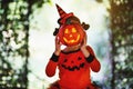 Happy Halloween! horrible creepy child girl in pumpkin costume