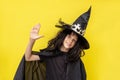 happy Halloween kid holds his hand up. Child in black sorcerer& x27;s costume. Witch cheerfully smiles and looks at the Royalty Free Stock Photo