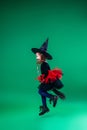 Happy Halloween! little girl in a black hat and a witch costume on a broom