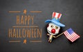 Happy Halloween logo on black background with wooden funny bozo ghost toy and American fla