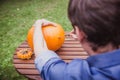 Happy halloween. Man carving big pumpkin Jack O Lanterns for Halloween outside. Close-up