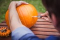 Happy halloween. Man carving big pumpkin Jack O Lanterns for Halloween outside. Close-up Royalty Free Stock Photo