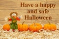 Happy Halloween message with scarecrow and orange pumpkins on straw hay Royalty Free Stock Photo