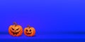 Happy halloween minimal creative banner with two orange scary pumpkins on purple background. Place for text Royalty Free Stock Photo