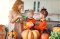 Happy Halloween! mother treats children with candy at home Royalty Free Stock Photo