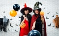 Happy Halloween party event with Asian pretty two girl witch and vampire makeover style while holding pumpkin bucket and balloons Royalty Free Stock Photo