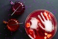 Happy Halloween party flat lay composition. Bowl of bloody color drink, frozen hands, cocktails glasses on black background. Top