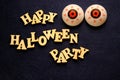 HAPPY HALLOWEEN PARTY and two balls of eye on a dark blue background. Words of wooden letters. Decoration for the holiday. Royalty Free Stock Photo