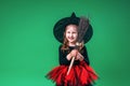 Happy Halloween! Portrait little girl in black hat and witch costume with broom Royalty Free Stock Photo