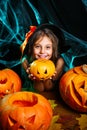 Happy halloween. Pretty little child girl in witch costume with carving pumpkin . Happy family preparing for Halloween. Royalty Free Stock Photo