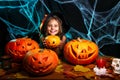 Happy halloween. Pretty little child girl in witch costume with carving pumpkin . Happy family preparing for Halloween. Royalty Free Stock Photo