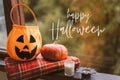 Happy Halloween. Pumpkin and candles on a cozy window sill with a red plaid. Royalty Free Stock Photo