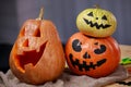 Happy Halloween. Pumpkin Jack o Lantern with a carved smile and two more pumpkins with creepy faces are on the table Royalty Free Stock Photo