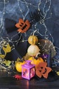 Happy Halloween, pumpkins, scary face carved on autumn leaves, mystical decor and a lantern with a burning candle on a bla